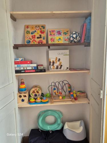 une petite salle de jeux pour enfants avec des étagères et des jouets dans l'établissement Au logis de Abi, à Cherbourg en Cotentin