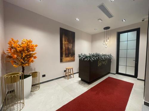 a lobby with a red rug and a plant at PineHill Hotel, Restaurant , Pool & Spa - RAZEM in Razëm