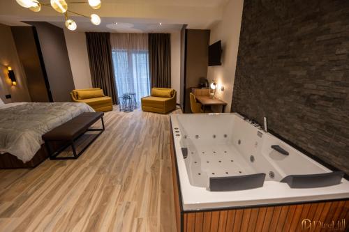 a hotel room with a large tub in a bedroom at PineHill Hotel, Restaurant , Pool & Spa - RAZEM in Razëm