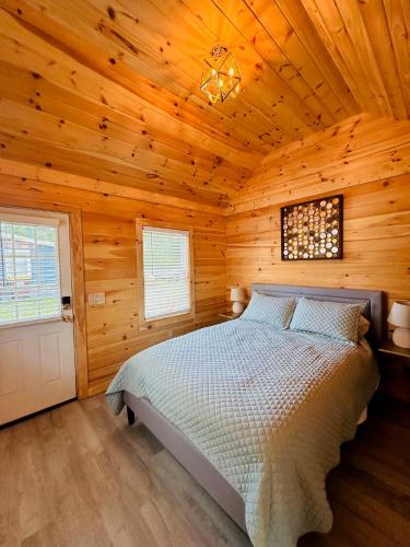 a bedroom with a bed in a wooden cabin at Saratoga Cabins in Malta