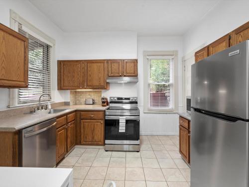 a kitchen with wooden cabinets and a stainless steel refrigerator at Oakland, Pittsburgh !B Stylish and Quiet Private Bedroom with Shared Bathroom in Pittsburgh