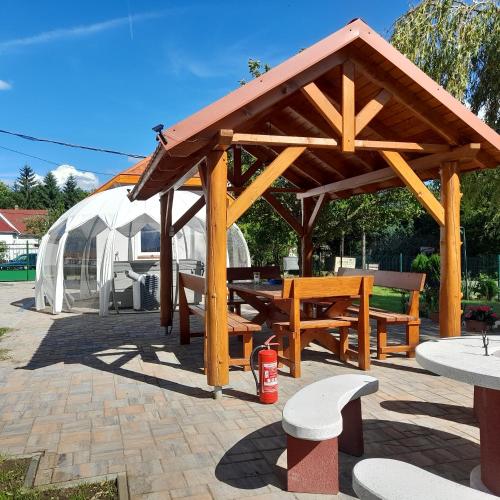 a wooden pavilion with a picnic table and a tent at Mátra Gold Vendégház in Mátraszentimre