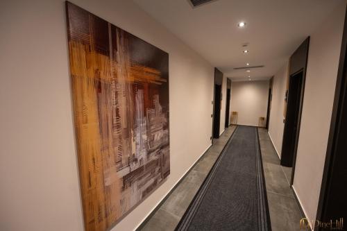 a hallway with paintings on the walls of a building at PineHill Hotel, Restaurant , Pool & Spa - RAZEM in Razëm