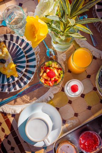 una mesa con platos de comida y un bol de fruta en Riad Dar Beldia and Spa, en Marrakech