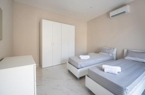 a bedroom with two beds and a white cabinet at 2 bedroom apartment in gudja in Gudja