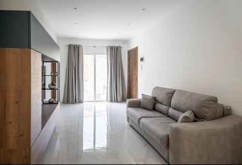 a living room with a couch and a television at 2 bedroom apartment in gudja in Gudja