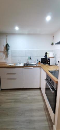 une cuisine avec des armoires blanches et un comptoir dans l'établissement Entre Tour Luma et Arènes, à Arles