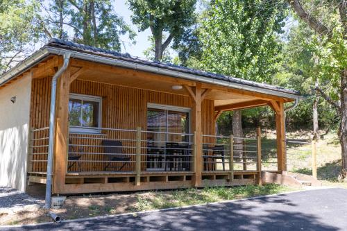 a log cabin with a porch and a deck at Camping Alpes Dauphiné in Gap