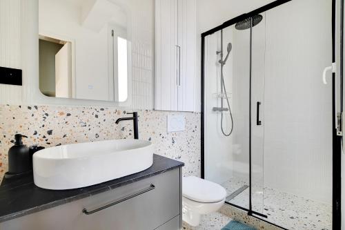 une salle de bain avec un lavabo, des toilettes et une douche dans l'établissement La Maison Bizot 51 T1 by ecoflats, à Paris
