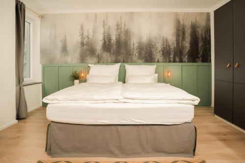 a large bed in a room with a painting on the wall at Hirschenhof Apartments in Spital am Semmering