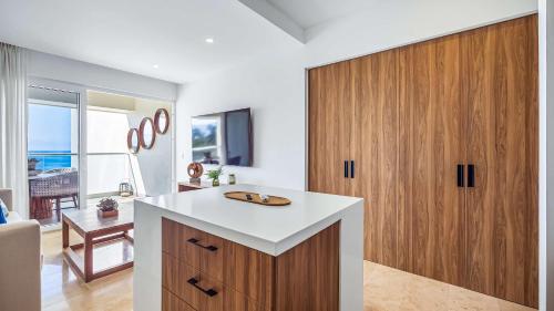 a kitchen with a sink and a wooden cabinet at Oceanfront 1BR with Balcony - Sea View & Pools in Puerto Vallarta