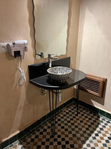 a bathroom with a sink and a table in a room at Riad Hanael Garden & Spa in Fès