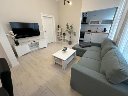 a living room with a gray couch and a table at ElbPerle Meißen-Altstadt WLAN Parken WOHLFÜHLEN in Meißen
