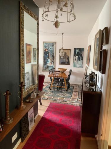 a living room with a table and a red rug at Retrohenkinen taiteilijakoti - Tampere Kaleva in Tampere