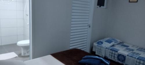 a small bathroom with a bed and a toilet at Pousada Canto dos Passaros in Chapada dos Guimarães