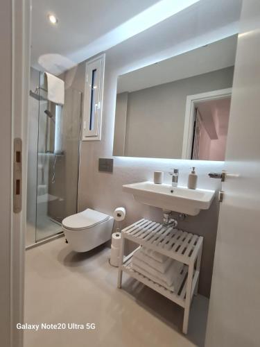 a bathroom with a sink and a toilet and a mirror at Hi Hellas 4 in Artemida