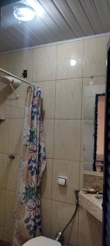 a bathroom with a toilet and a shower curtain at Pousada Canto dos Passaros in Chapada dos Guimarães