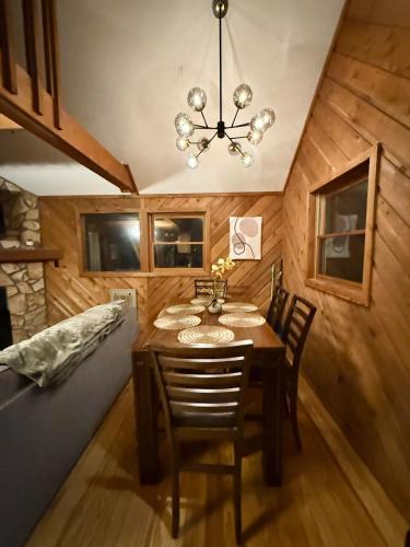 a dining room with a table and chairs and a chandelier at Plentiful Porches - Hot Tub - King Bed - Views in Banner Elk