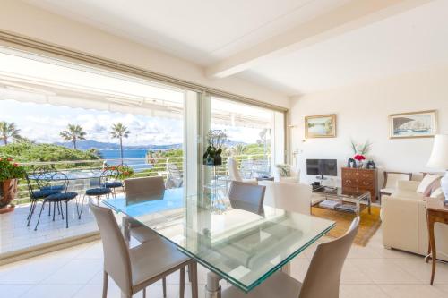 une salle à manger avec une table en verre et une vue sur l'océan dans l'établissement Sea View 95m Apartment with Large Terrace Cannes Croisette, à Cannes