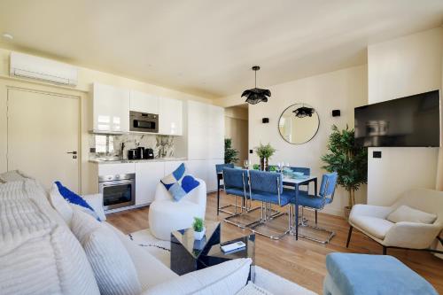 - un salon avec un canapé blanc et des fauteuils bleus dans l'établissement La Maison Bizot 53 T3 by ecoflats, à Paris