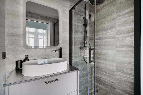 une salle de bain avec un lavabo et un miroir dans l'établissement La Maison Bizot 53 T3 by ecoflats, à Paris