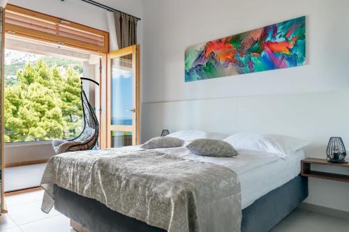 Un dormitorio con una cama y una ventana grande. en Apartment Bikin 2, en Brela