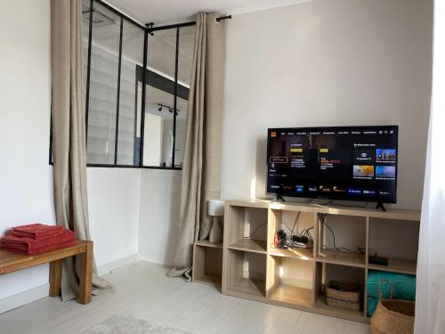 Una sala de estar con un televisor de pantalla plana sobre un soporte. en Saint Nazaire 4 chbres 15min de la plage à Saint Marc KER LOT MARC, en Saint-Nazaire