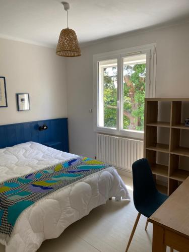 une chambre avec un lit, un bureau et une fenêtre dans l'établissement Saint Nazaire 4 chbres 15min de la plage à Saint Marc KER LOT MARC, à Saint-Nazaire