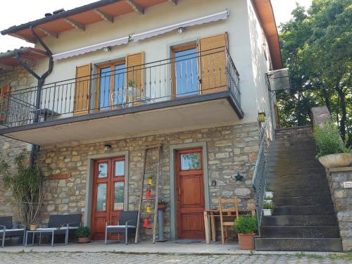 a building with a balcony and doors and chairs at Casa Campomonte in Poppi
