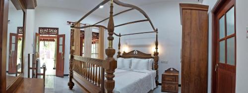 a bedroom with a canopy bed in a room at Charika Villa in Bentota