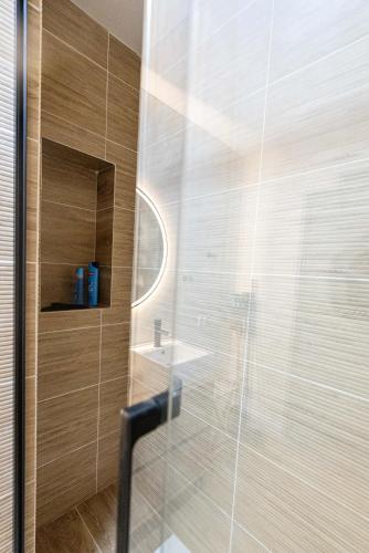 d'une douche avec une porte en verre et un lavabo. dans l'établissement T2 à l'Ile Rousse proche mer et centre, à LʼÎle-Rousse