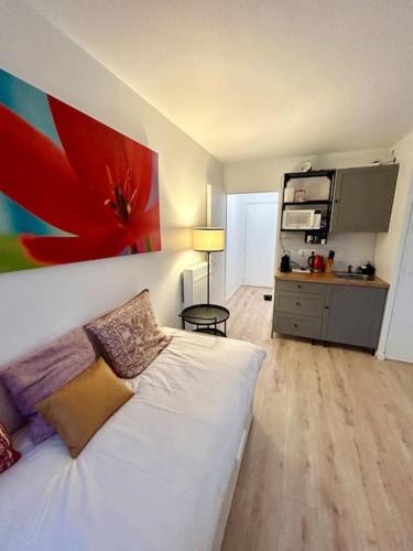 - un salon avec un canapé blanc orné d'une peinture murale dans l'établissement Cosy studio Disney, à Serris