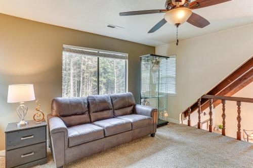 a living room with a couch and a ceiling fan at Private Cabin with Forest Views and Grill in Lakehead! in Lakehead