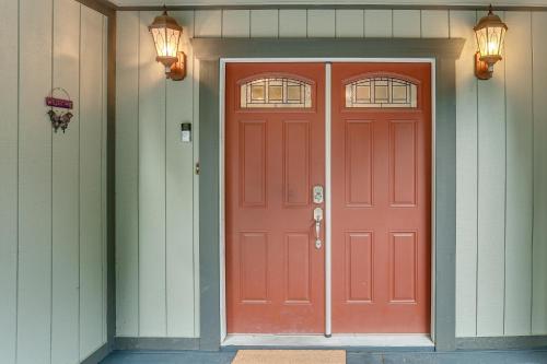 a red door on a house with two windows at Private Cabin with Forest Views and Grill in Lakehead! in Lakehead