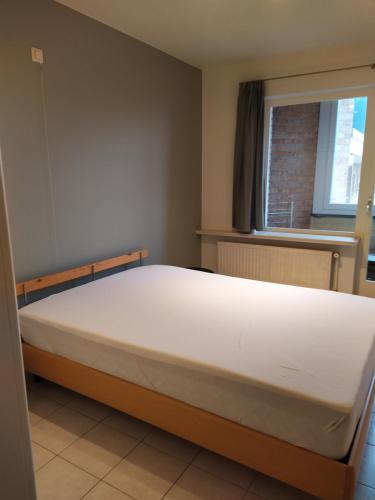 a large bed in a room with a window at Residentie Rapallo in Middelkerke