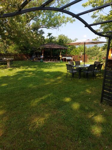 a table and chairs in a yard with an umbrella at Casa Campomonte in Poppi