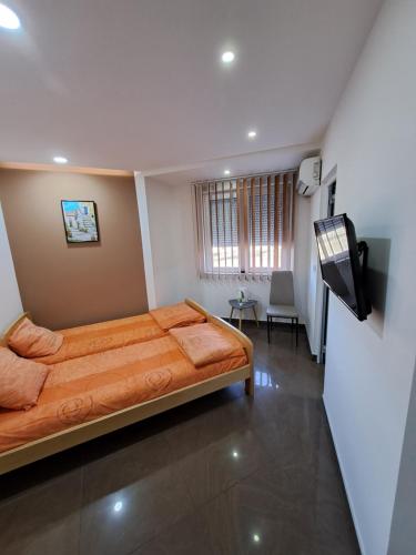a bedroom with a bed and a flat screen tv at Lena lux in Jagodina