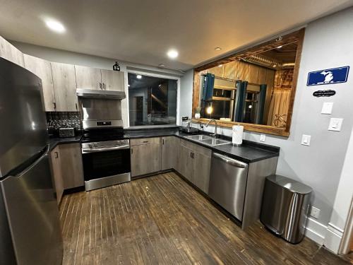 a kitchen with stainless steel appliances and wooden floors at 1 Mile From Boyne Mt- Chateau Patak in Boyne Falls