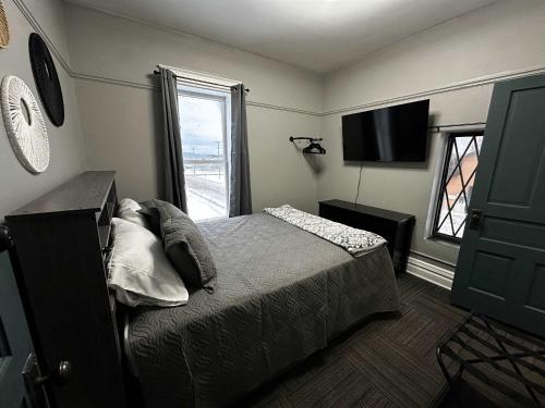a bedroom with a bed and a tv and a window at 1 Mile From Boyne Mt- Chateau Patak in Boyne Falls
