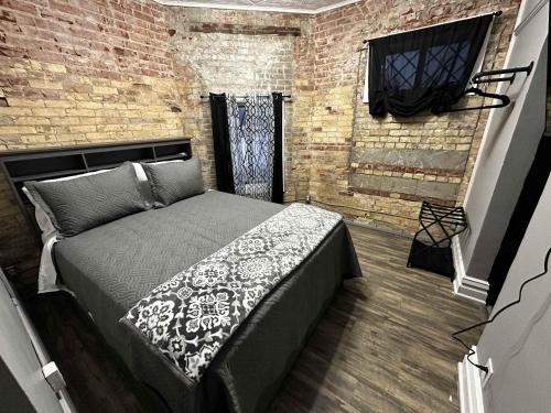 a bedroom with a bed and a brick wall at 1 Mile From Boyne Mt- Chateau Patak in Boyne Falls
