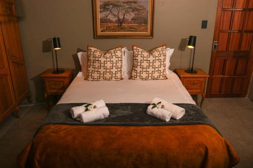 a bedroom with a large bed with two towels at Diamantvallei Landgoed in Rayton