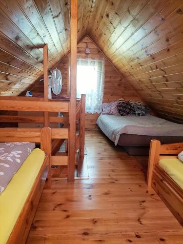 a room with two beds in a wooden cabin at Domki na Chabrowej in Augustów