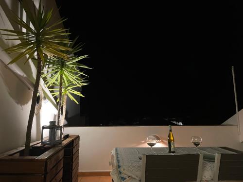a dining room with a table and a palm tree at Golden Club- Eyes on Sea in Cabanas de Tavira