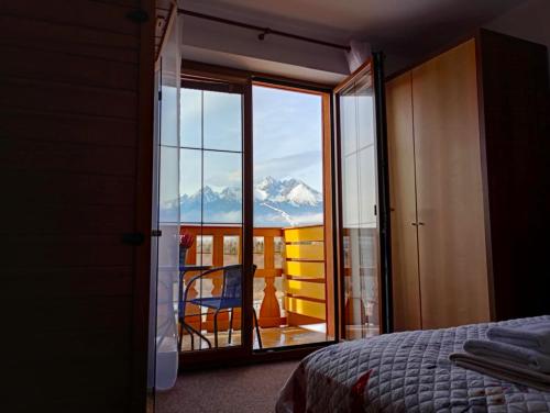 a bedroom with a view of a mountain through a glass door at Tatry PANORAMA apartmány Tatragolf in Tatranská Lomnica