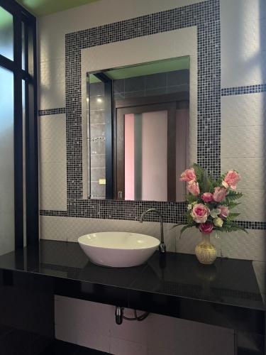 a bathroom sink with a vase of flowers on a counter at Pool villa Phuket in Kata Beach