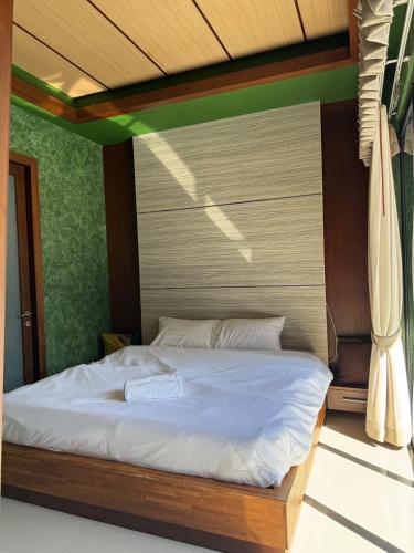 a bedroom with a large bed with white sheets at Pool villa Phuket in Kata Beach