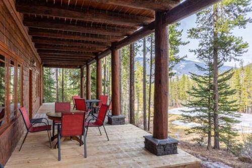 a screened porch with red chairs and a table on it at Ravenwood Cabin by StayIn in Panorama