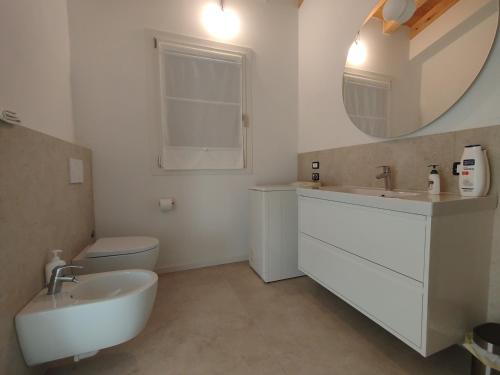 a bathroom with a sink and a toilet and a mirror at Agriturismo Casa Bregalda in Castelgomberto