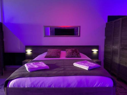 - une chambre violette avec un lit à éclairage violet dans l'établissement Suite Dream, à Montigny-lès-Cormeilles