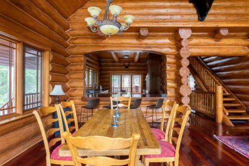 a dining room with a wooden table and chairs at Ravenwood Cabin by StayIn in Panorama